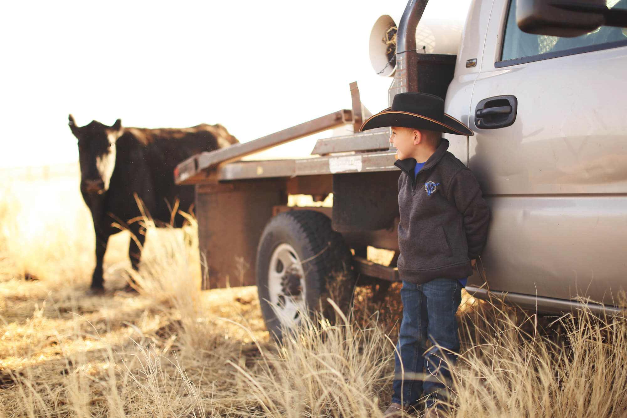 Boy wearing wester wear standing by truck