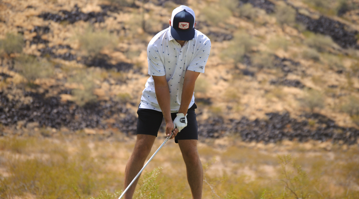 Cowboy golfing while wearing a men's western polo.