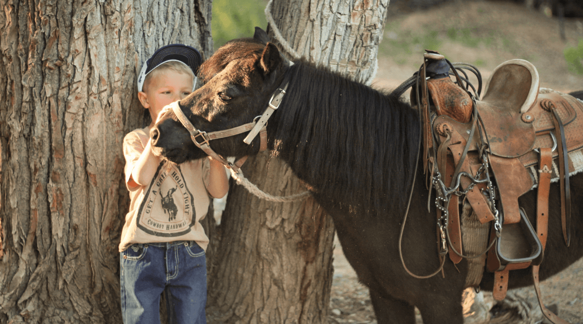 little cowboy and his horse wearing items from Cowboy Hardware's Spring and Summer Collection