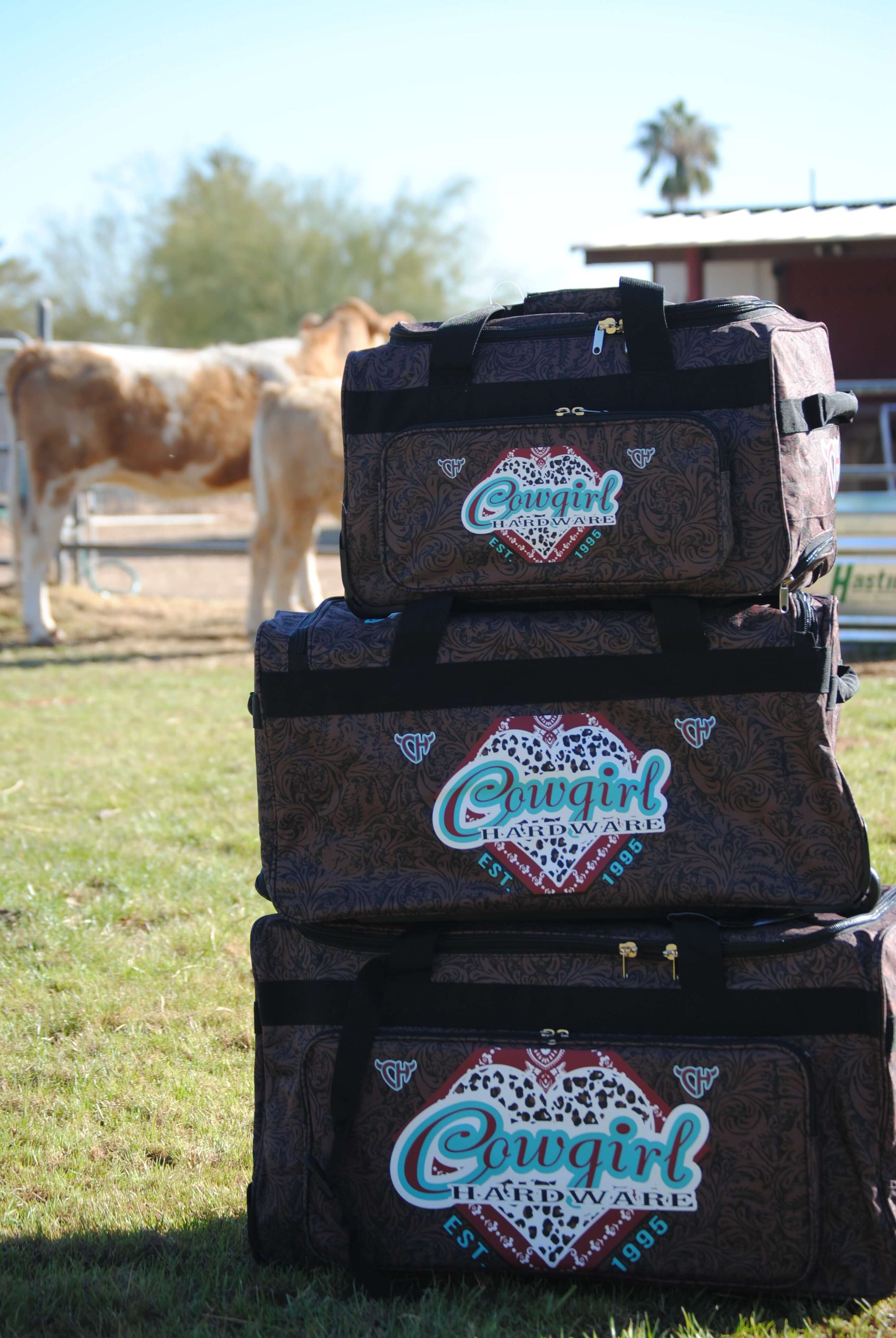 All Three Sizes Stacked Of Our CH Fancy Heart Tooled Leather 3 Wheel Gear Bags from Cowgirl Hardware