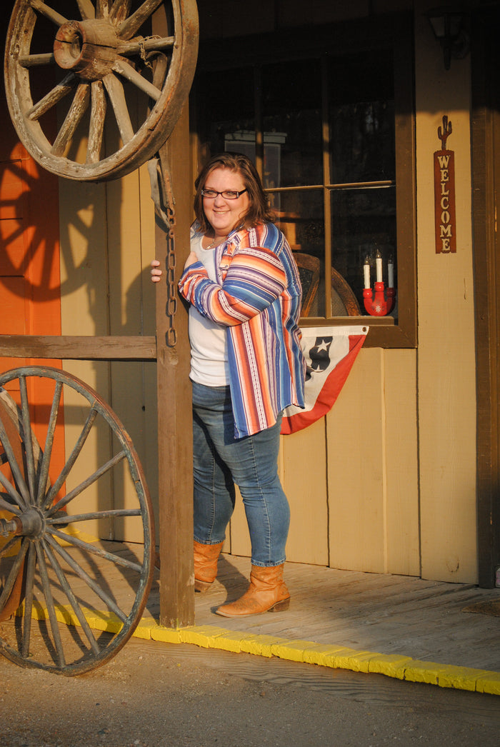 Cowgirl wearing an orange chevron serape long sleeve shirt by Cowboy Hardware