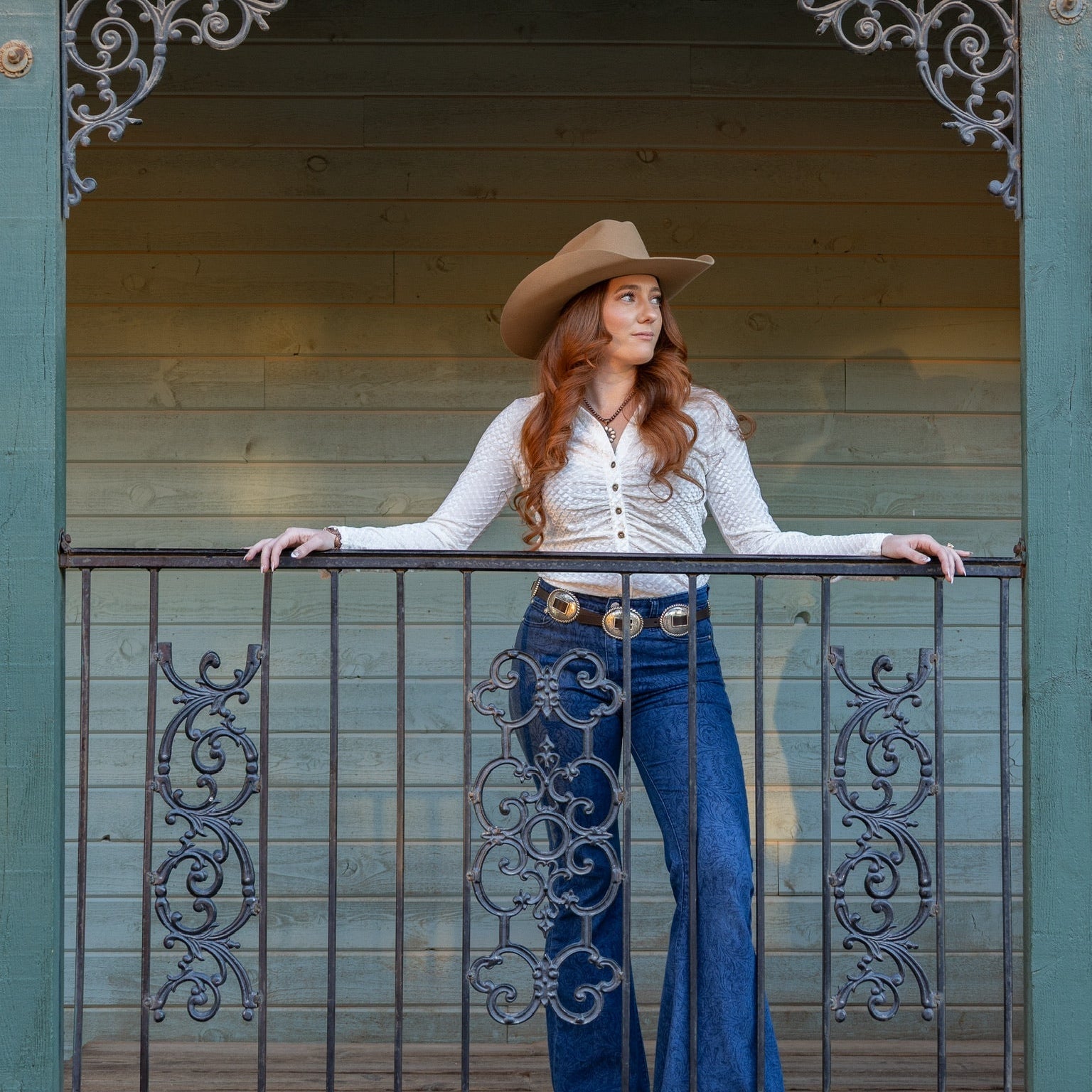 Cowgirl wearing a CH White "Velvet Button Up V-Neck" Long Sleeve Top looking out on the ranch
