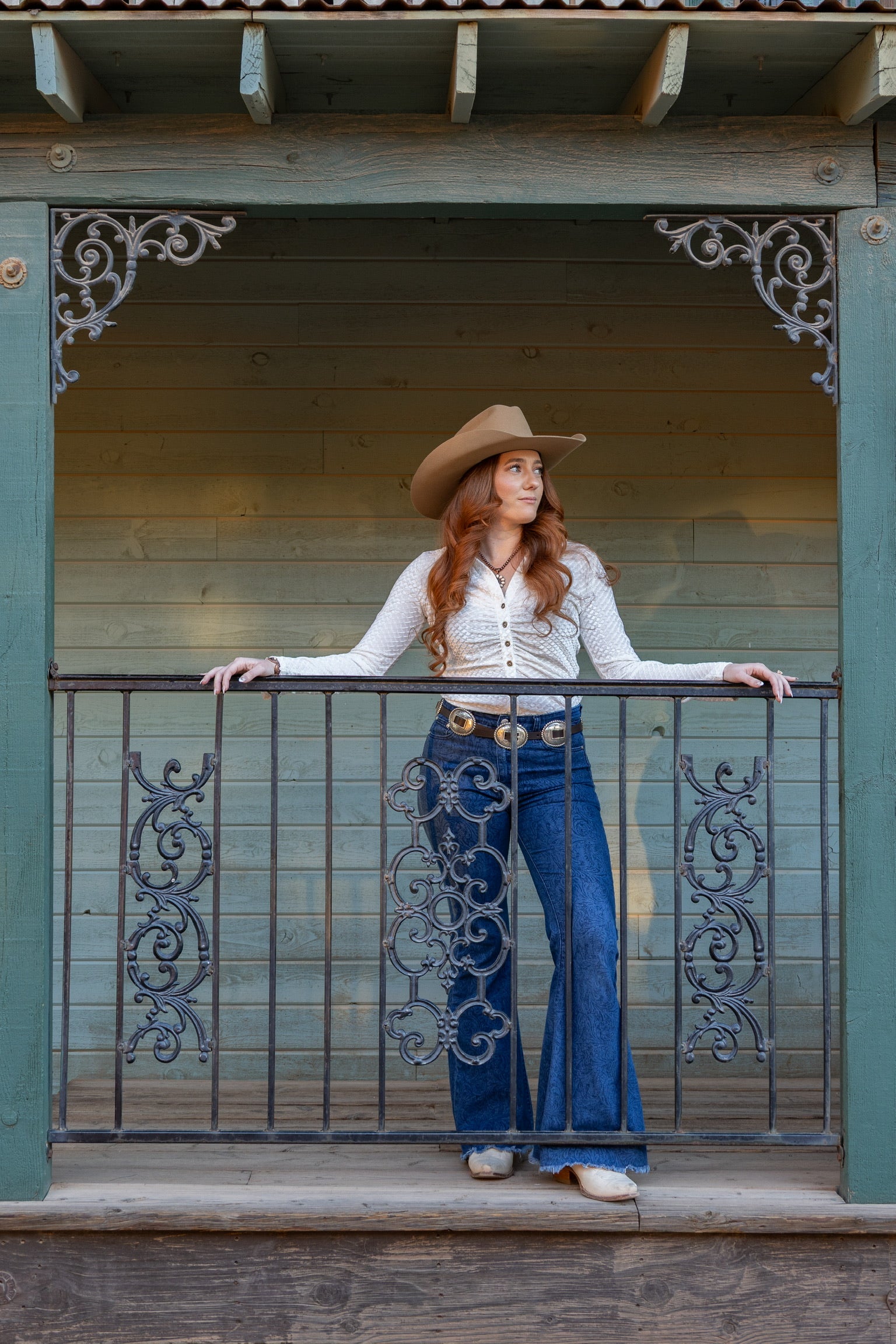 Cowgirl wearing a CH White "Velvet Button Up V-Neck" Long Sleeve Top looking out on the ranch