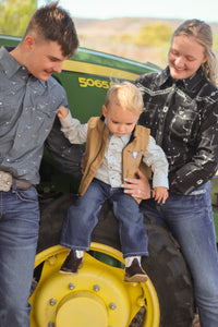 Family with a child on a tractor in an outdoor setting