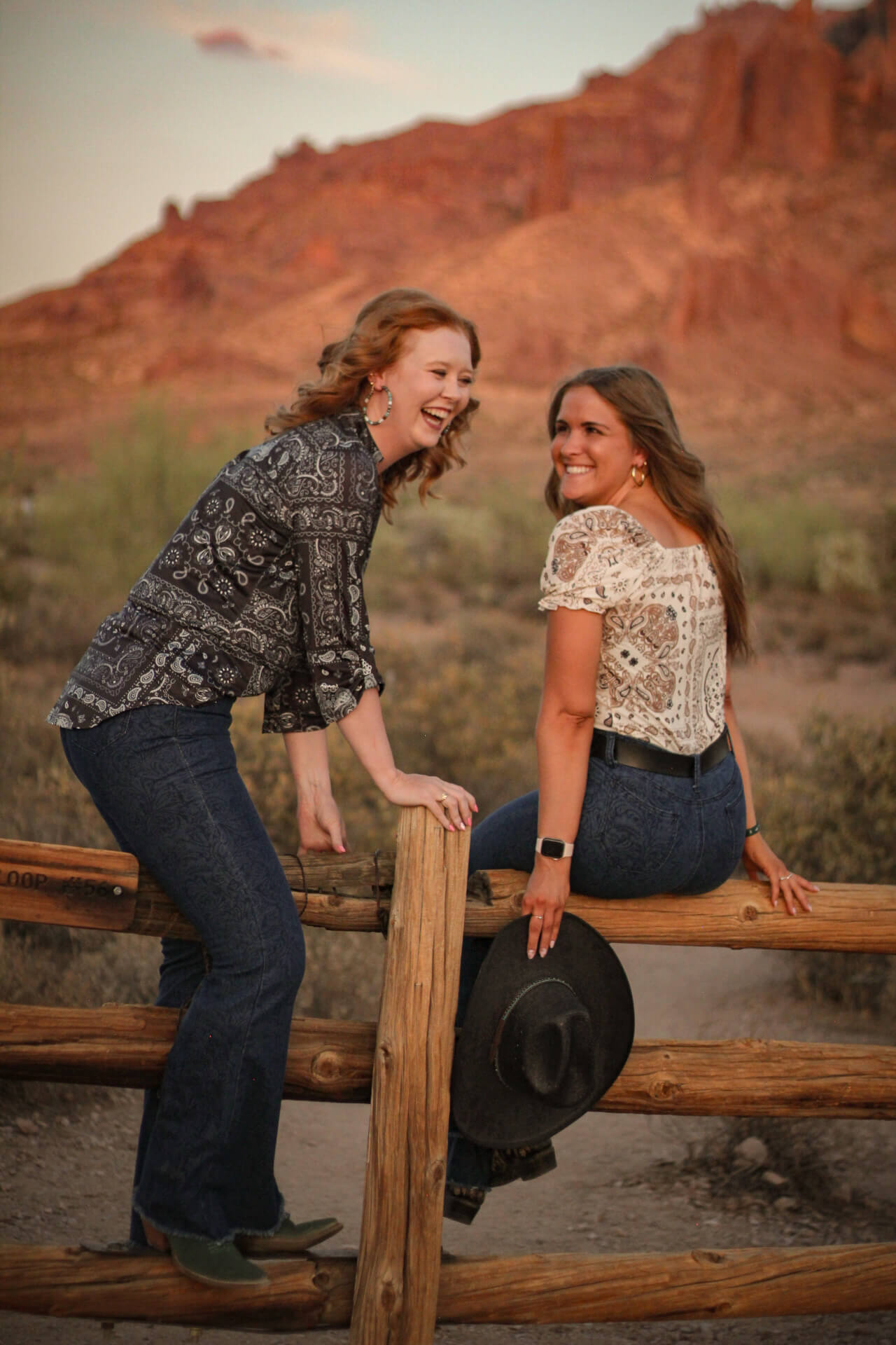 Best friends enjoying the sunset in the desert, wearing women’s Patchwork Bandana Short Sleeve Blouse from Cowgirl Hardware.