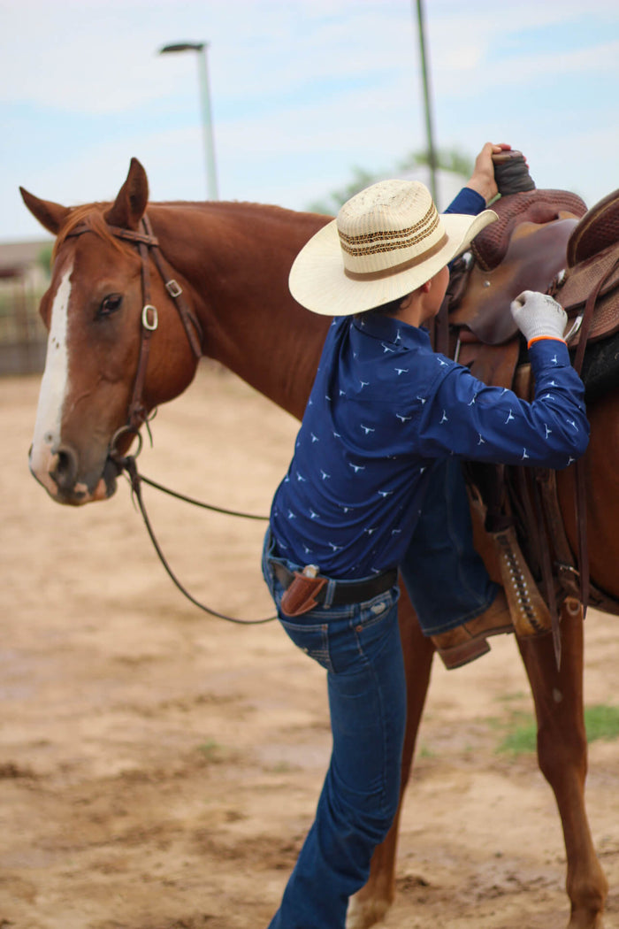 Cowboy getting onto his horse.