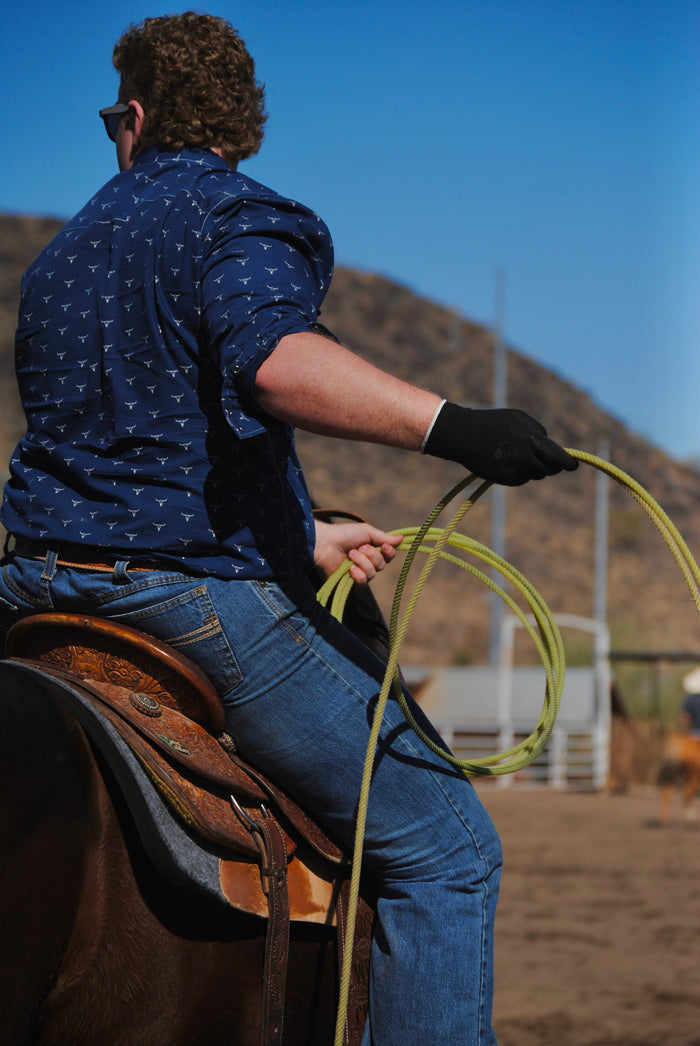 Cowboy riding and roping in Cowboy Hardware's navy skull burst long sleeve western shirt