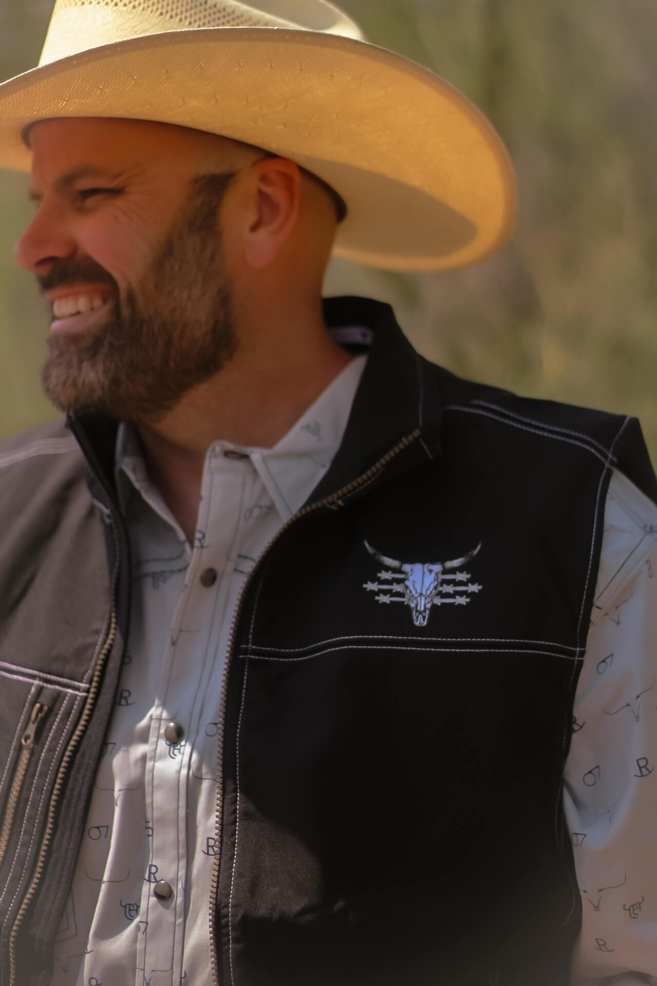 Cowboy wearing a Men's Cowboy Hardware Black Live Free Tech Woodsman Vest.