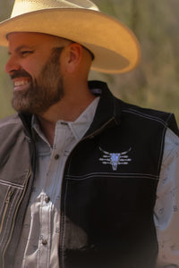 Cowboy wearing a Men's Cowboy Hardware Black Live Free Tech Woodsman Vest.