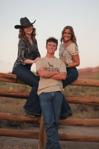 Cowboy with some friends hanging out at the ranch, wearing a Men's Cowboy Hardware Desert Sand "Buck Shack" Short Sleeve T-Shirt