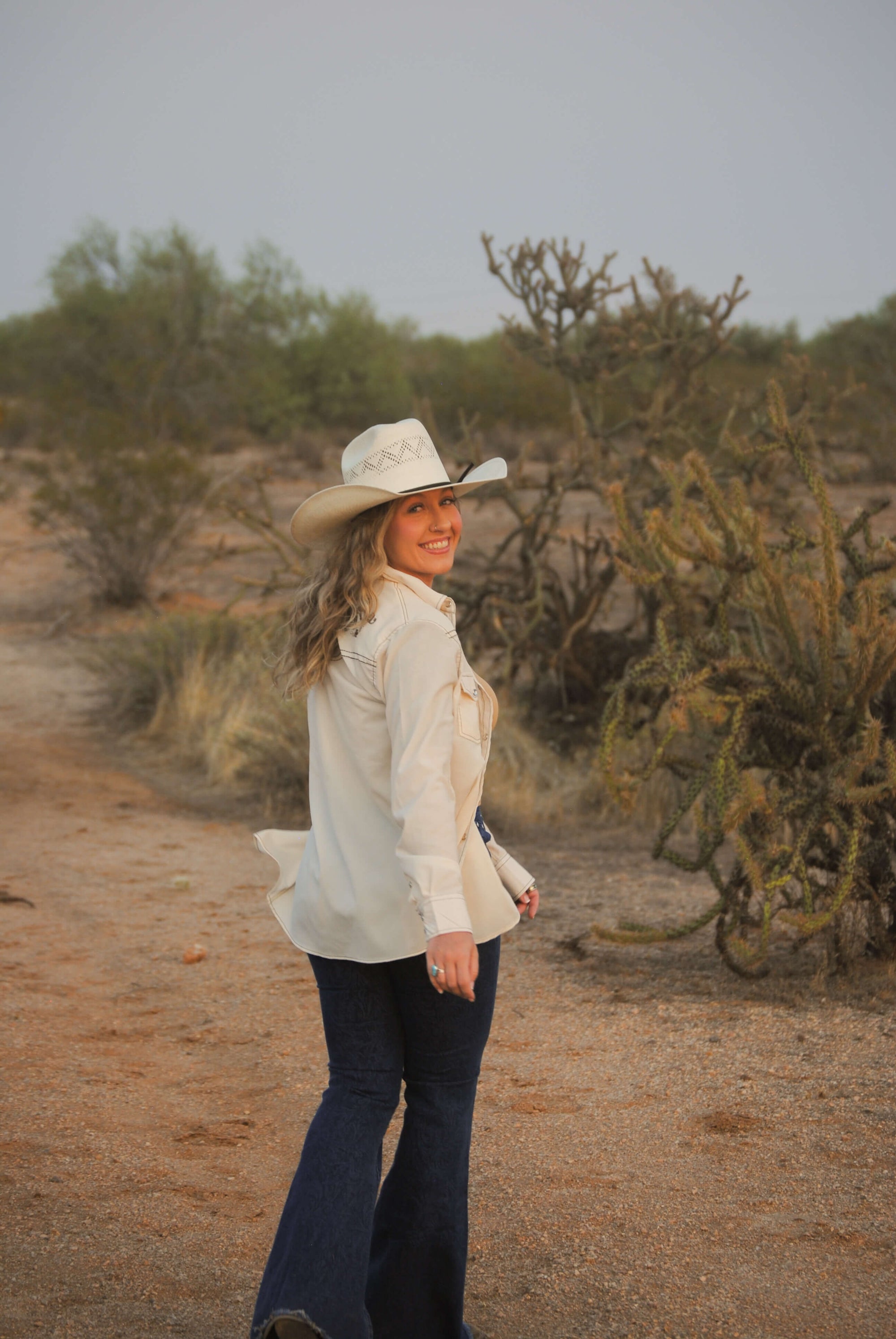 Cowgirl enjoying the desert sunset wearing a Women's Cowgirl Hardware Vintage Off-White Embroidered Long Sleeve Solid Western Shirt