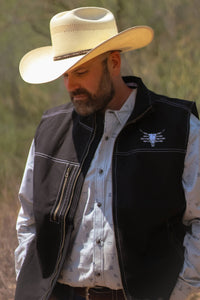 Handsome cowboy checking his crops, wearing a Cowboy Hardware Black Live Free Tech Woodsman Vest.