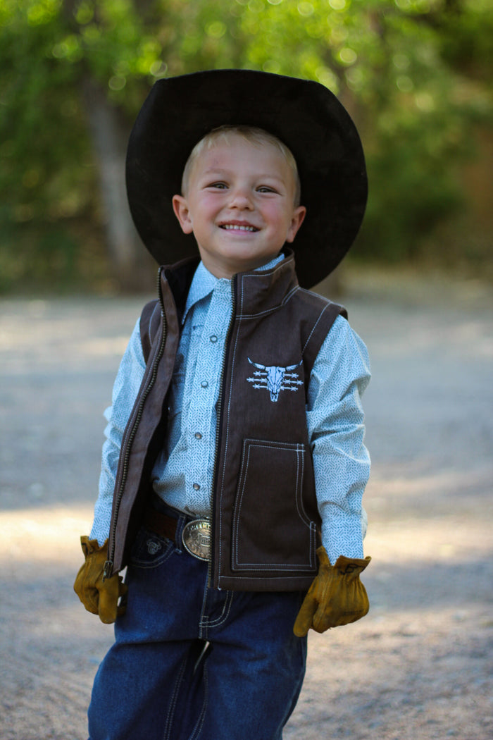 Little cowboy smiling wearing riding gloves wearing boy's Cowboy Hardware dark chocolate live free tech woodsman vest