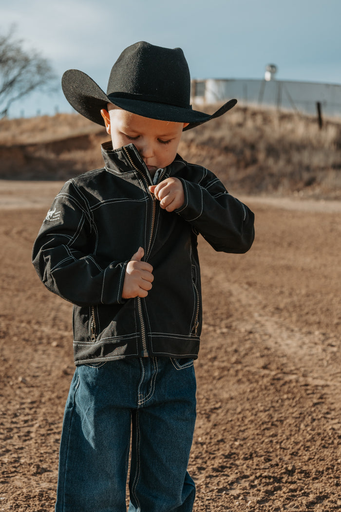 Little cowboy zipping up his CH jacket, preparing for morning chores.