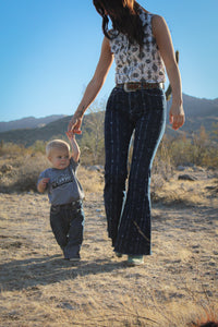 Toddler cowboy holding mother's hand walking wearing Cowboy Hardware's denim triple barbed jeans