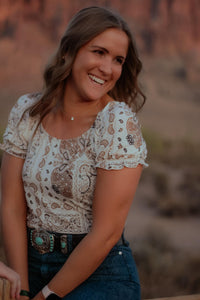 Woman laughing while wearing Cowgirl’s Hardware Patchwork Bandana Short Sleeve Blouse.