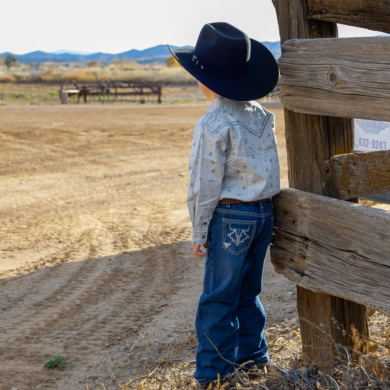 Young cowboy admiring the farm.