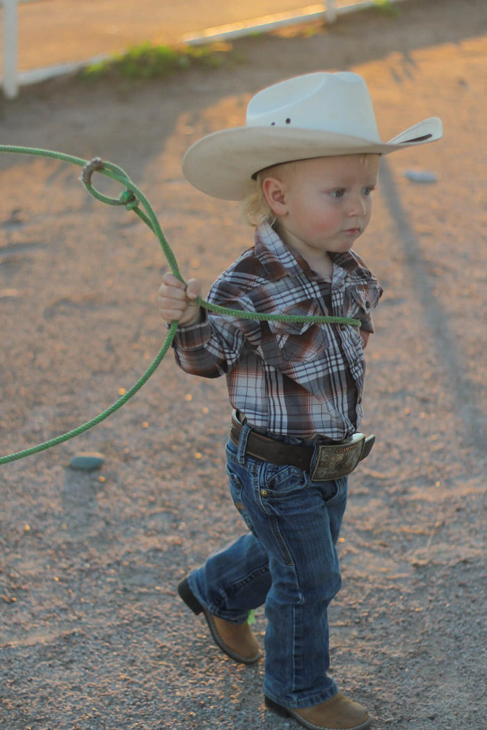 Young cowboy learning how to rope.