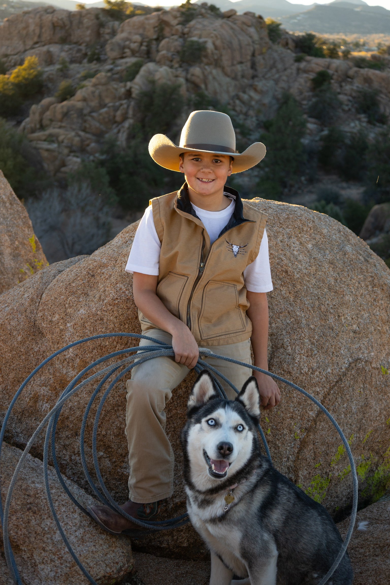 Young cowboy with his dog enjoying the outdoors