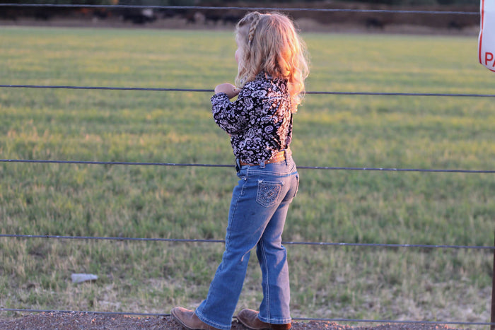 Young cowgirl checking on her horses.