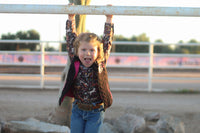 Young cowgirl playing near the corral
